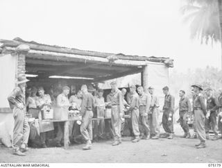 SIAR, NEW GUINEA. 1944-08-09. THE MID-DAY MESS PARADE IN PROGRESS AT B COMPANY, 25TH INFANTRY BATTALION. IDENTIFIED PERSONNEL ARE:- VX43106 LIEUTENANT R.L. BARTLETT (1); Q21901 WARRANT OFFICER II, ..