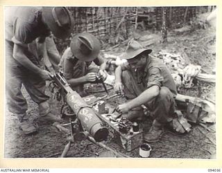 KUNAI RIDGE, NEW GUINEA, 1945-07-11. MEMBERS OF A MEDIUM MACHINE-GUN SECTION OF A COMPANY, 2/5 INFANTRY BATTALION, GIVING THEIR VICKERS A THOROUGH CLEANING BEFORE AN ATTACK. "STUTTERING STELLA II", ..