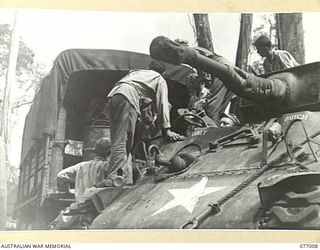 BOUGAINVILLE ISLAND, 1944-11-13. AMERICAN TROOPS FILLING THE FUEL TANKS OF A NEW TYPE OF FLAME THROWER FITTED TO A GENERAL SHERMAN M4A3 MEDIUM TANK WHICH IS BEING DEMONSTRATED TO AUSTRALIAN AND ..