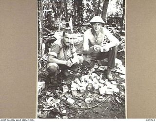 1943-09-20. NEW GUINEA. BUSO RIVER. LAE AREA. AUSTRALIAN TROOPS OPEN UP TINS OF BULLY BEEF. LEFT TO RIGHT - PTE. J. HILL, OF LIDCOMBE, N.S.W., N.S.W., AND CPL. W. MCDONALD OF HAMILTON, NEWCASTLE, ..