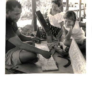 Photo of 'Sebal. Hamlet of Koror, Palau District, Western Caroline Islands. Carver specialises in painted carved story boards'.