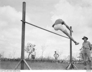 HERBERTON, QLD. 1945-01-19. SERGEANT SHOOBRIDGE, 2/8 FIELD REGIMENT, (1), CLEARING THE BAR AT 5 FEET 5 INCHES DURING THE 9 DIVISION GYMKHANA AND RACE MEETING HELD AT HERBERTON RACECOURSE. AT THE ..