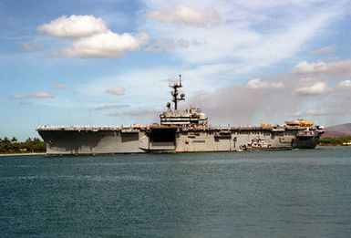 The large harbor tug NIANTIC (YTB-781) pulls alongside the amphibious assault ship USS TRIPOLI (LPH-10) as the ship departs from the naval station. The TRIPOLI is en route to its home port of Naval Station, San Diego, Calif., after serving in the Persian Gulf region during Operation Desert Shield and Operation Desert Storm.