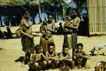 [Three women and six children with two dogs in background], at a Lake Murray village, [Papua New Guinea], c1958