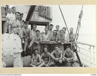 1943-05-07. NEW GUINEA. MILNE BAY. AN ALLIED VESSEL HIT DURING THE 1943-04-14, JAPANESE RAID ON MILNE BAY. PICTURE SHOWS SOME OF THE CREW. (NEGATIVE BY N. BROWN)