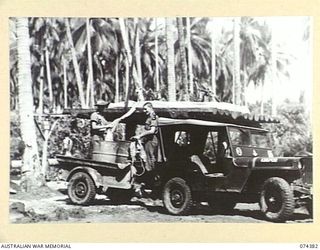 SIAR, NEW GUINEA. 1944-06-27. THE WATERING POINT AND SHOWERS AT HEADQUARTERS, 15TH INFANTRY BRIGADE. IDENTIFIED PERSONNEL ARE:- QX5846 PRIVATE G. BALLINGER (UNDER SHOWER) (1); VX106355 DRIVER T.K. ..