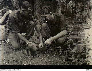 Berimu Village, New Guinea. 1945-08-05. NX89477 Corporal C.C.B. Warren, on the left, and NX16628 Private C.F. Cunningham of the 2/7th Australian Infantry Battalion, AIF, on a six day patrol into ..