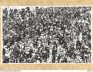 MELBOURNE, AUS. 1943-11-18. CROWD BREAKING THROUGH THE BARRIERS AT THE CONCLUSION OF THE TRIUMPHANT MARCH THROUGH THE CITY BY TROOPS OF THE 17TH AUSTRALIAN INFANTRY BRIGADE, ON ITS RETURN TO THE ..