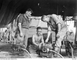 BOUGAINVILLE. 1945-04-27. MAJOR GENERAL C.H. SIMPSON, SIGNAL OFFICER IN CHIEF (3), INSPECTING CHOREHORSE CHARGERS AT 3 DIVISION SIGNALS (AIF), DURING HIS VISIT TO SOUTH BOUGAINVILLE TO INSPECT ..