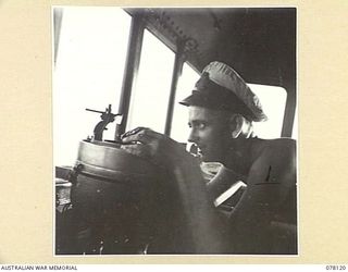 MADANG, NEW GUINEA. 1944-11-20. AN OFFICER OF THE ROYAL AUSTRALIAN NAVY VESSEL, HMAS "BENDIGO" TAKING A COMPASS BEARING