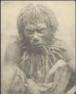 Papuan man from the bush wearing a fern collar smoking a European pipe, Papua, ca. 1922 / Sarah Chinnery