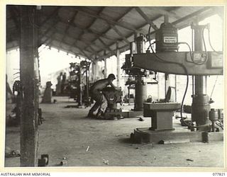 LAE BASE AREA, NEW GUINEA. 1944-12-27. QP8340 STAFF SERGEANT G.E. POWELL WORKING AT A RADIAL DRILL IN THE MACHINE SHOP OF THE 13TH WORKSHOPS AND PARK COMPANY