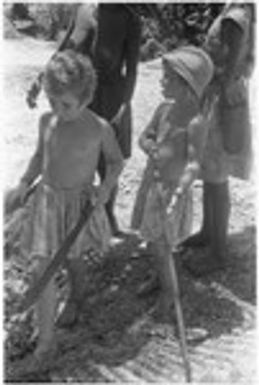 Lauren Keesing with machete and Felicia Keesing with carved stick