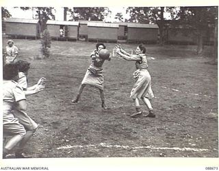 INDOOROOPILLY, BRISBANE, QUEENSLAND. 1945-02-19. LANCE-CORPORAL H. FROGGART, (3), SCRAMBLING FOR THE BALL DURING RECREATIONAL BASKETBALL TRAINING DURING THE VISIT BY COLONEL S.H. IRVING, CONTROLLER ..