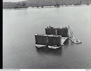 PACIFIC OCEAN. C.1945. TWO SECTIONS OF AN ADVANCED BASE SECTIONAL DOCK OF THE US NAVY BEING WELDED TOGETHER AT A PACIFIC ISLAND BASE. A CRANE ON A PONTOON ASSISTS IN THE TASK. (NAVAL HISTORICAL ..