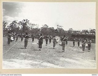 HERBERTON, QLD. 1945-01-20. THE REGIMENTAL BAND, 2/9 CAVALRY (COMMANDO) REGIMENT, GIVE A DEMONSTRATION DURING A LULL IN THE RACING PROGRAMME. THEY ARE PARTICIPATING IN THE 9 DIVISION GYMKHANA AND ..
