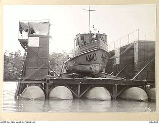 LAE AREA, NEW GUINEA. 1944-12-17. THE 12 SMALL SHIP COMPANY CRAFT AM 10 DOCKED FOR REPAIR AT HERZOG LAGOON. THIS IS THE FIRST VESSEL TO MAKE USE OF THIS DOCK