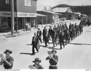 HERBERTON, QLD. 1944-04-25. THE BAND OF THE 2/2ND INFANTRY BATTALION LEADING A MARCH OF RETURNED SERVICEMEN OF THE FIRST WORLD WAR, SECOND WORLD WAR, AND TROOPS OF THE 6TH DIVISION AT J. D. SYME, ..