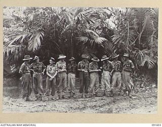 KARAWOP, NEW GUINEA. 1945-05-05. OFFICERS OF 2/1 INFANTRY BATTALION REST AT THE UNIT'S REAR ECHELON AFTER THEIR SWIFT DRIVE DOWN THE COAST. THEY ARE NOW WITHIN THREE MILES OF WEWAK. IDENTIFIED ..