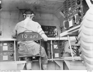 KATIKA, NEW GUINEA. 1944-03-31. NX65187 SIGNALMAN C. STRAHAN, B AUSTRALIAN CORPS SIGNALS, TRANSMITTING A MESSAGE ON THE 188F (UNITED STATES ARMY 191F), WIRELESS TRANSMITTER-RECEIVER. WHEN NOT IN ..