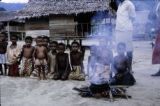 Papua New Guinea, children sitting by fire in village