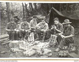 GOODVIEW, NEW GUINEA, 1943-08-05. ORDNANCE AND AUSTRALIAN ARMY SERVICE CORPS ATTACHED TO THE 17TH INFANTRY BRIGADE PERSONNEL SETTING AND RECHECKING FUSES ON 3" MORTAR BOMBS, AFTER THEY HAVE BEEN ..