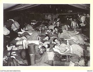 AT SEA, OFF SOUTH BOUGAINVILLE. 1945-09-09. TROOPS OF THE BUIN LIAISON GROUP, 2 CORPS, SETTLE DOWN FOR THE NIGHT ABOARD THE AV2056 EVELYN FOR THE TRIP TO BUIN