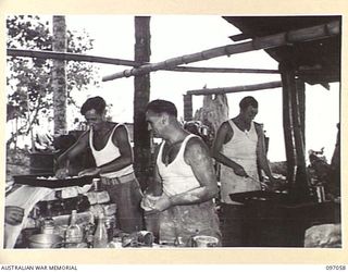 TUNNEL HILL ROAD, RABAUL, NEW BRITAIN. 1945-09-20. COOKS OF 22 INFANTRY BATTALION PREPARING THE EVENING MEAL IN THE COOKHOUSE BY THE WATER'S EDGE. FOLLOWING THE SURRENDER OF THE JAPANESE TROOPS OF ..