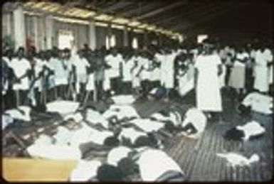 Several people on the floor in trance, in front of spectators, and Holy Mama