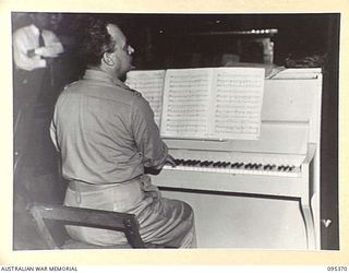 TOROKINA, BOUGAINVILLE, 1945-08-16. MR ERIC FOX, PRINCIPAL PIANIST, TAKING PART IN A CONCERT AT HEADQUARTERS 2 CORPS ARRANGED BY THE GRACIE FIELDS CONCERT PARTY