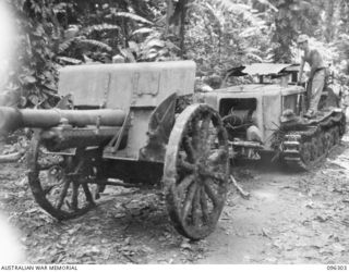 KAHILI, SOUTH BOUGAINVILLE. 1945-09-09. A PRIME MOVER PULLING A HEAVY ARTILLERY PIECE ALONG THE ROAD. THE JAPANESE WORKED TO ASSEMBLE ALL WEAPONS, AFTER THE ARRIVAL OF BUIN LIAISON GROUP, 2 CORPS, ..