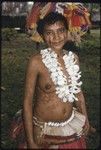 New mother wearing shell belt and necklace, fiber skirt, flower garland, and skirt valuable on head, and red betel nut paste on face, word tattooed on left arm, marks on body may be skin fungus