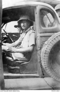 N85247 Lieutenant (Lt) D M Selby, Officer Commanding the Anti Aircraft Battery Rabaul, and his driver N108194 (NX191448) Lance Bombardier (L Bdr) B R Hartigan in the battery's Ford utility truck ..