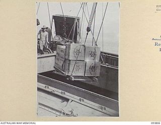 LAE AREA, NEW GUINEA, 1945-07-11. THE MID-YEAR HAMPERS DISTRIBUTED BY THE AUSTRALIAN COMFORTS FUND, LAE DISTRIBUTION CENTRE, BEING LOADED FOR SHIPMENT TO OPEN BAY, NEW BRITAIN