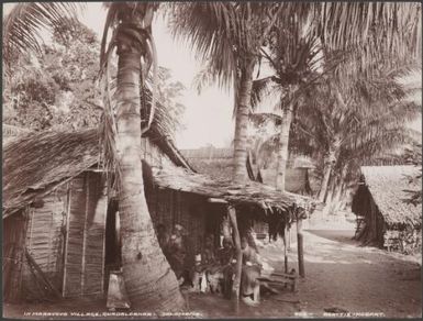 Villagers sitting outside a house in Maravovo village, Guadalcanar, Solomon Islands, 1906 / J.W. Beattie