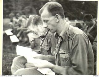 KILIGIA, NEW GUINEA. 1944-04-10. Q104999 SIGNALMAN A.T. BERRY (1), AND QX40751 CORPORAL H.M. RENNER (2), AT HEADQUARTERS 5TH DIVISION AREA, READING BEFORE COMMENCEMENT OF THE UNIT MOVIE "CHARLEY'S ..