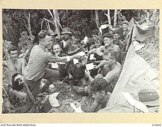 NEW GUINEA. UPPER RAMU VALLEY ADVANCE. 1 NOVEMBER 1943. THE POSTMAN ARRIVES WITH WELCOME MAIL AT AN ADVANCED POST. (NEGATIVE BY G. SHORT)