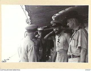 AITAPE, NEW GUINEA. 1945-02-28. VX17 MAJOR- GENERAL J.E.S. STEVENS, DSO, ED, GENERAL OFFICER COMMANDING 6TH DIVISION BEING GREETED BY THE CAPTAIN OF THE HMAS "SWAN" LIEUTENANT W.J. DOVERS AND HIS ..