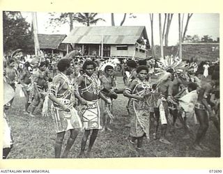 HIGITURA, NEW GUINEA. 1944-04-27. OROKAIVAS PERFORMING A DANCE CEREMONY AT THE HEADQUARTERS OF THE MAMBARE DISTRICT OFFICER, AUSTRALIAN NEW GUINEA ADMINISTRATIVE UNIT, IN HONOUR OF THE VISIT TO THE ..