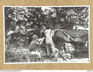 HUON PENINSULA AREA, NEW GUINEA. 1944-01-08. PERSONNEL OF "A" SQUADRON, 1ST TANK BATTALION PULLING BACK A MATILDA TANK ARMED WITH A 3 INCH HOWITZER TO CHECK ITS RECOIL AT THE WORKSHOP AREA OF THE ..