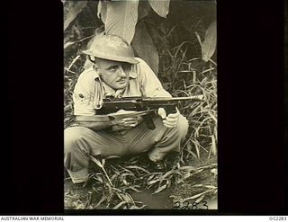 TOROKINA, BOUGAINVILLE ISLAND, SOLOMON ISLANDS. C. 1945-02-23. 24008 FLIGHT SERGEANT K. W. BROWN OF TOWNSVILLE, QLD, AT THE READY WITH TOMMY GUN IN JUNGLE EXERCISES IN THE TOROKINA AREA