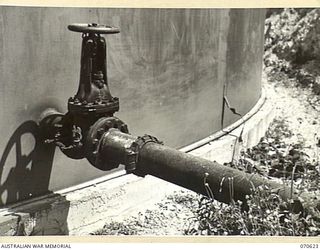 PORT MORESBY, PAPUA, 1944-02-25. THE OUTLET PIPE, SHOWING MAIN VALVE AND BYPASS VALVE, ON THE "G" STORAGE TANK AT THE 1ST PETROLEUM STORAGE COMPANY
