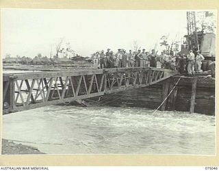 LAE, NEW GUINEA. 1944-08-09. TROOPS OF THE 20TH FIELD COMPANY, RELAXING AFTER GETTING THE FIRST STEEL BOX GIRDER SECTION OF THE NEW BRIDGE ACROSS THE BUTIBUM RIVER WHICH IS TO REPLACE THE OLD ..