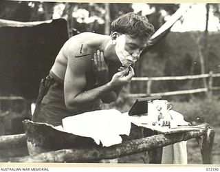 NEW GUINEA. 1944-04-03. VX125532 SIGNALMAN P. O'DONOHUE, SHAVES AT A CAMP WASH STAND AT THE 23RD LINE SECTION, 18TH LINES OF COMMUNICATION SIGNALS