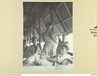 SOUTH ALEXISHAFEN, NEW GUINEA. 1944-08-08. NFX76286 SISTER I.A. MORSE (4); CHECKING PULSE AND TAKING THE TEMPERATURE OF A PATIENT IN ONE OF THE TENT WARDS OF THE 111TH CASUALTY CLEARING STATION. ..