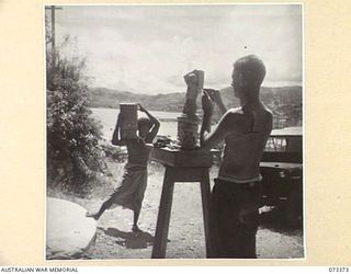PORT MORESBY, NEW GUINEA. 1944-05-23. VX93667 CAPTAIN G. H. ALLEN, OFFICIAL WAR ARTIST, MILITARY HISTORY SECTION, MODELLNG A NATIVE CARRIER OUTSIDE THE UNIT STUDIO