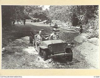 1943-09-14. NEW GUINEA. SUPPLIES ON THEIR WAY TO THE FRONT LINE IN NEW GUINEA. JEEPS TOOK THE SUPPLIES TO THE END OF THE ROAD AND FROM THERE NATIVE CARRIERS TRANSPORTED THEM TO FRONT LINES. ..