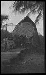 Man, woman, and children on walkway outside a house