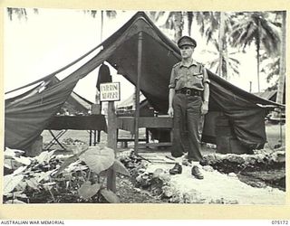 MILILAT, NEW GUINEA. 1944-08-09. NX137071 LIEUTENANT R.S. MCGOVERN, CATERING ADVISER, OUTSIDE HIS TENT OFFICE AT HEADQUARTERS, 5TH DIVISION