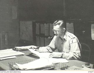 LAE, NEW GUINEA. 1944-09-06. CAPTAIN RICHARDS, DUTY OFFICER, WORKING IN THE BATTLE ROOM AT HEADQUARTERS, NEW GUINEA FORCE